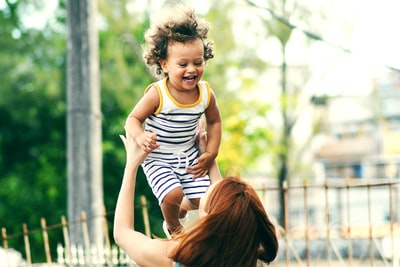 白天妇女抱孩子的选择性聚焦照片